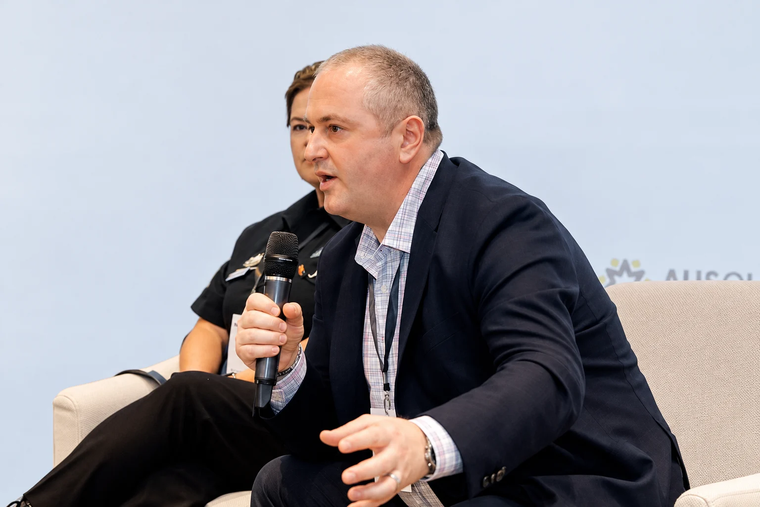 Mario speaking on a conference panel with a microphone
